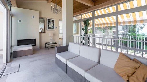 A modern, open-plan living area with a sofa set, a small table, and a TV. - Luxury Villa in Juan-les-Pins (Juan-les-Pins)