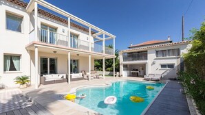 A two-story house with a swimming pool, outdoor seating, and a covered patio. - Luxury Villa in Juan-les-Pins (Juan-les-Pins)