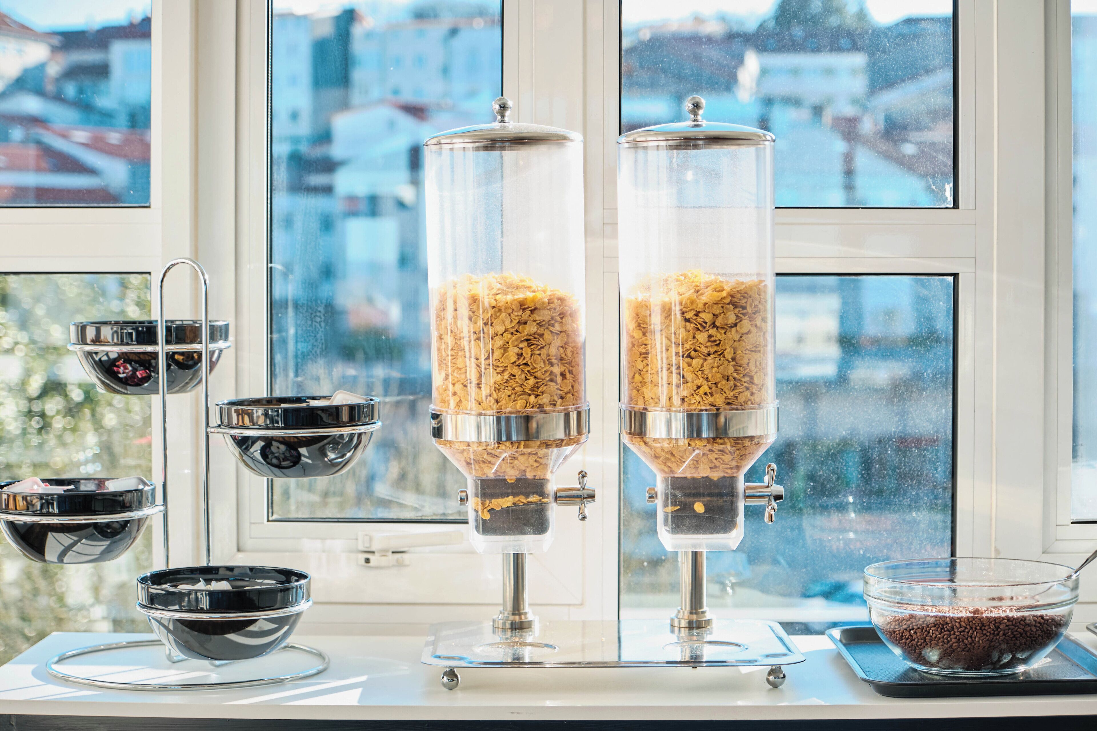 Una cocina con dos dispensadores de alimentos, un tazón de cereal y un tazón de chispas de chocolate.