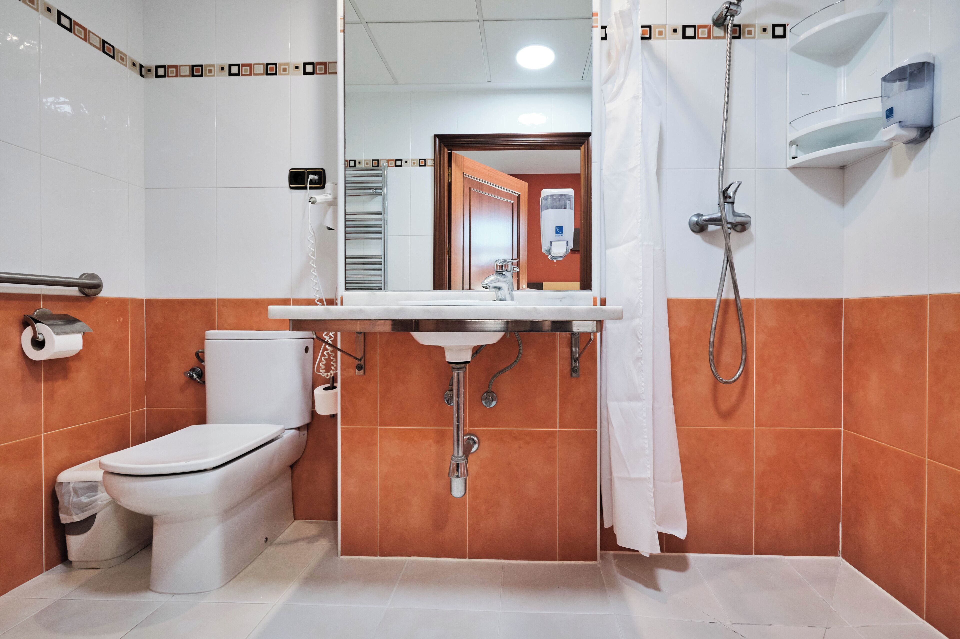 Un baño con inodoro, lavamanos y ducha.