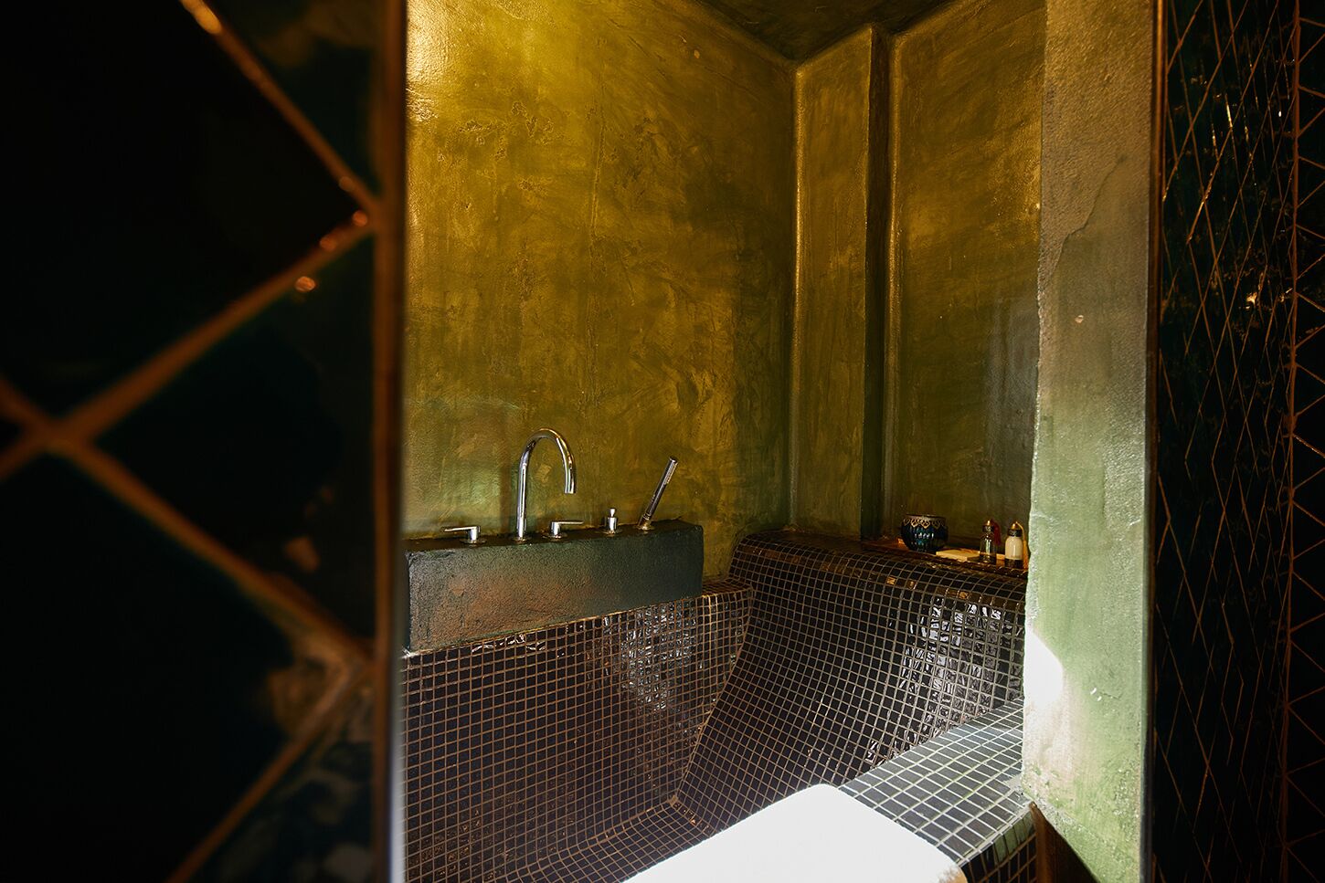 A bathroom with a tiled floor, a sink with a faucet, and a mirror.
