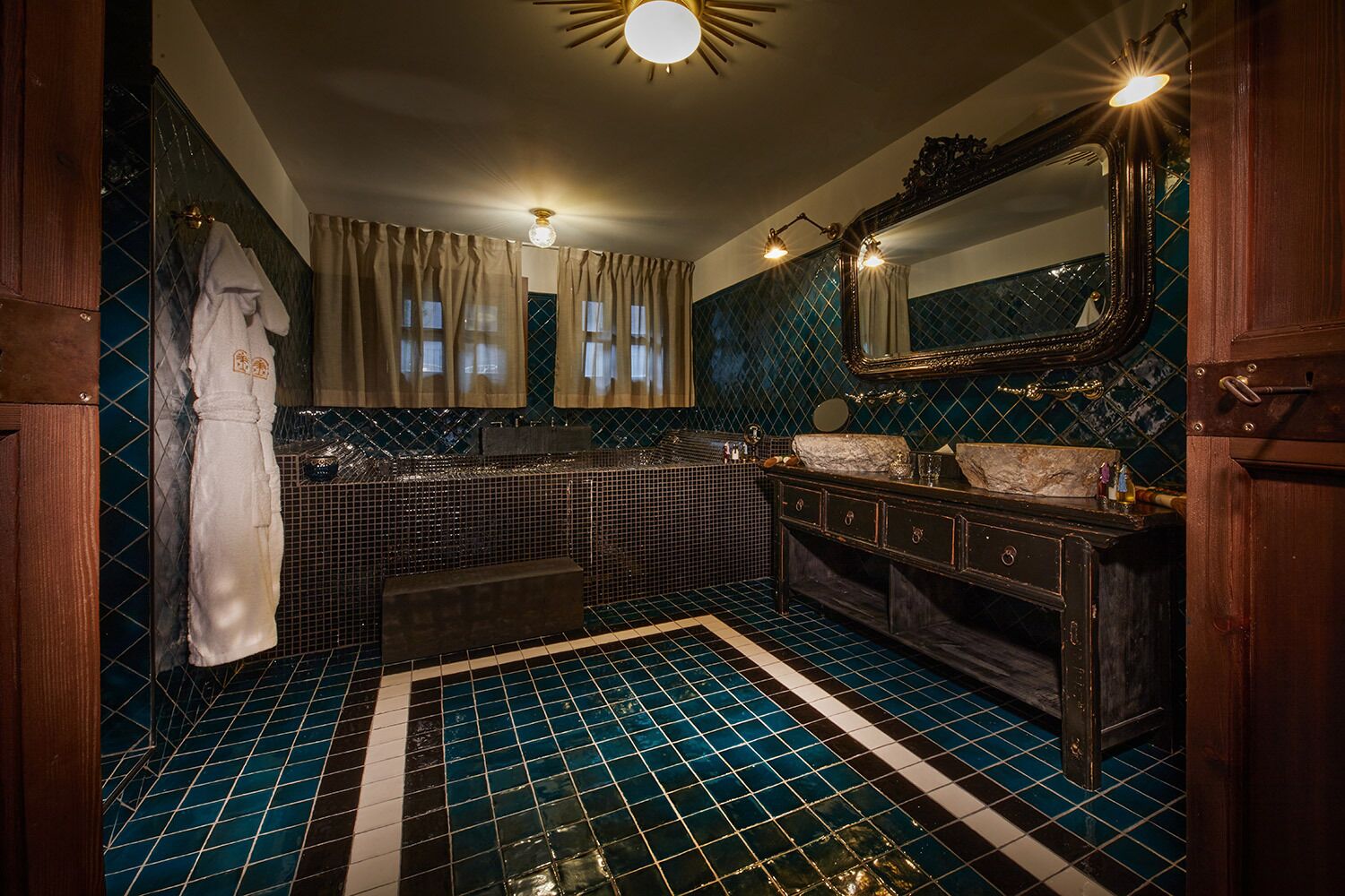 A bathroom with a checkered floor, a large mirror, a sink, and a bathtub.