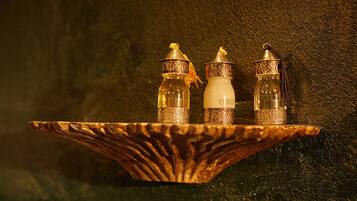 Three ornate bottles on a decorative tray against a textured wall.