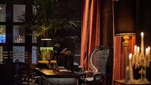 A dimly lit room with a wooden bar, a potted plant, and a chair. - Palma Riad (Palma de Mallorca)