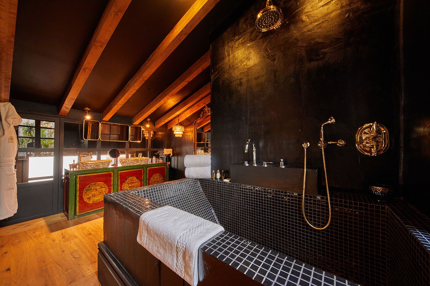 Um quarto de spa com uma banheira grande, teto de madeira e parede de pedra.