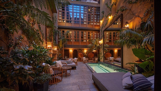 A multi-level indoor courtyard with a pool, seating areas, and lush greenery. - Palma Riad (Palma de Mallorca)