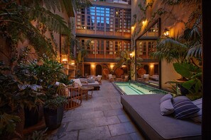 A multi-level indoor courtyard with a pool, seating areas, and lush greenery. - Palma Riad (Palma de Mallorca)