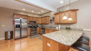 Una cocina moderna con armarios de madera, electrodomésticos de acero inoxidable y encimera de granito.