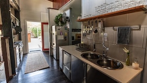 A modern kitchen with stainless steel appliances, a double sink, and a wine rack.