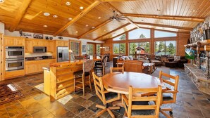 A spacious kitchen with wooden cabinets, a large island, and a dining area with a wooden table and chairs.