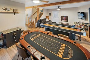 Een kamer met een pooltafel, een boekenkast en een televisie.
