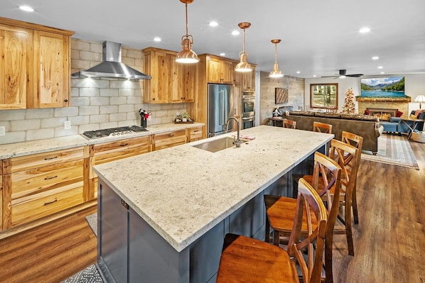A kitchen with wooden cabinets, a large island, and bar stools.