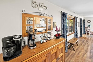A kitchenette with a coffee maker, a kettle, and a coffee station.