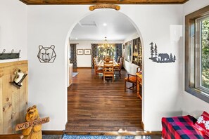 A wooden interior with a dining area, a welcome sign, and bear-themed decorations.