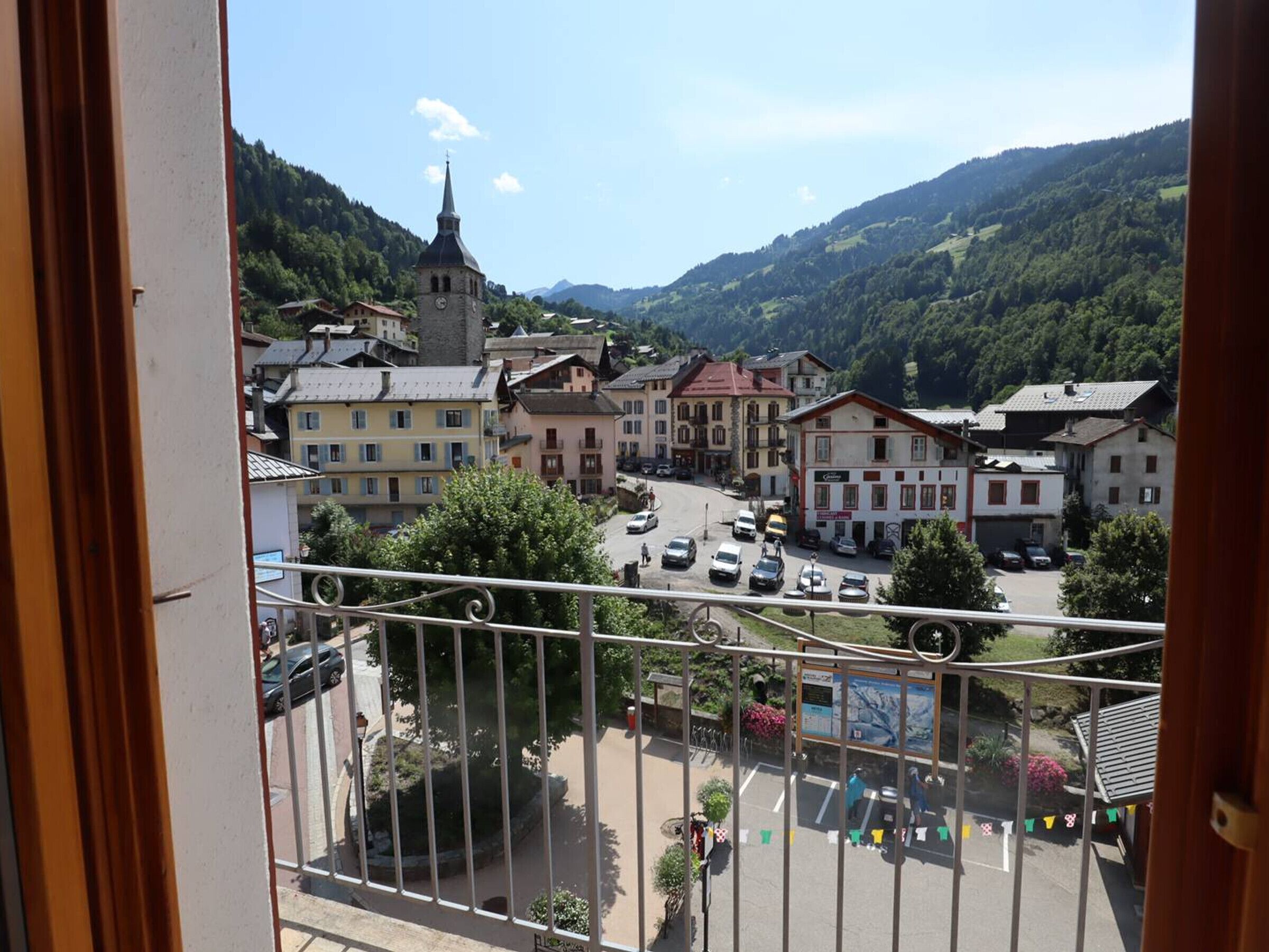 Une ville avec une église, des bâtiments aux couleurs vives et un paysage montagneux en arrière-plan.