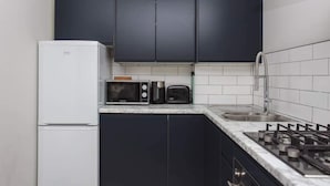 Eenvoudig appartement, meerdere bedden | Privékeuken | Een koffiezetapparaat/waterkoker, een koelkast, een magnetron, een oven