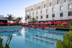 Una piscina al aire libre, camas de piscina gratis, sombrillas
