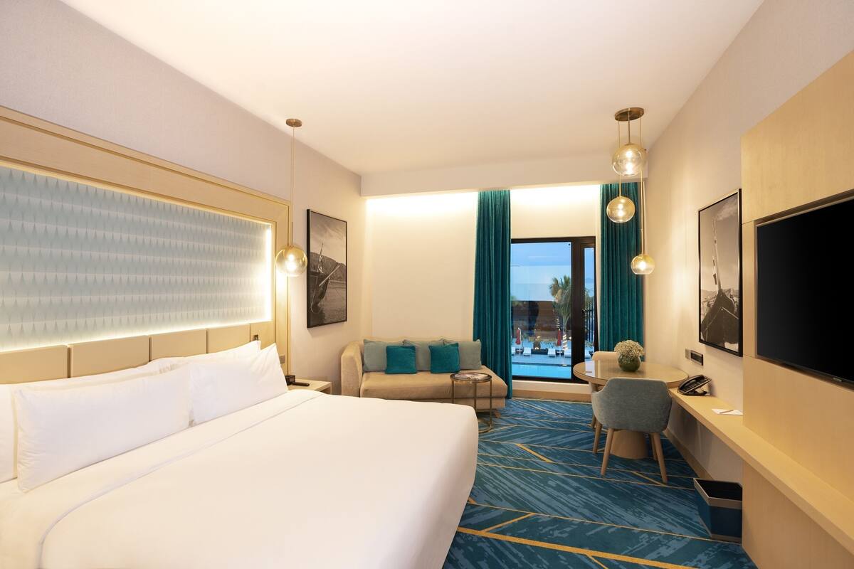 Une chambre d’hôtel avec un grand lit, un canapé, un bureau et une télévision.