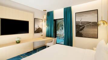 Quarto de hotel moderno com uma cama grande, uma escrivaninha com cadeira, televisão de tela plana e duas janelas amplas com cortinas verde-água.