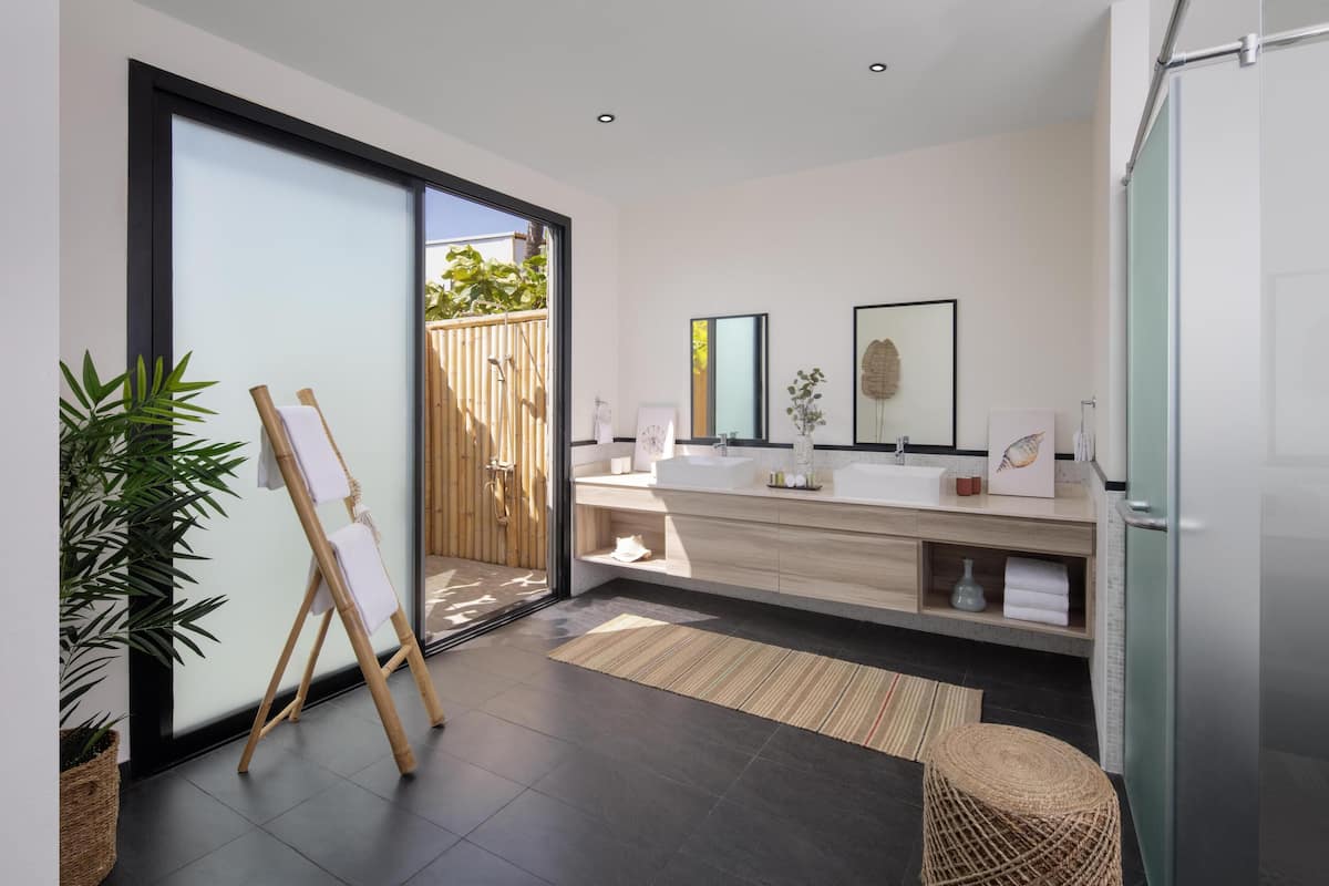 Une salle de bain moderne avec une grande fenêtre, un chevalet en bois et un lavabo avec un miroir.