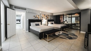 A modern hotel room with two beds, a large mirror, and a view of the city. - SVS: 3BD/3BA Penthouse | 1,600 sqft | Strip Views | Jockey Club (Las Vegas)