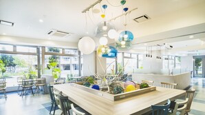 A modern dining area with a central island, chairs, and hanging spherical light fixtures. - Rembrandt Style Naha (Naha)