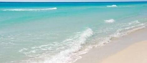 Enjoy a tranquil beach experience with calm waters gently lapping against the shore.