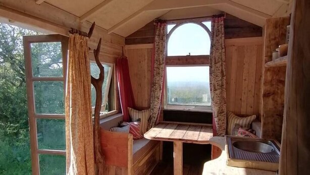 A rustic cabin with a wooden interior, a bench, a window with curtains, and a sink. - Totnes - Cabin - Sleeps 4 - Garden - Parking (Totnes)