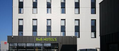A B&B hotel with a modern facade, large windows, and a visible entrance.