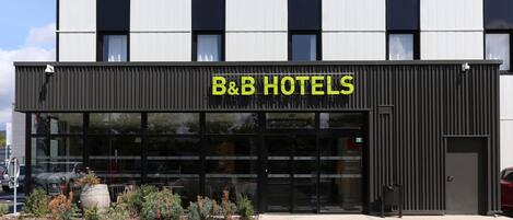A B&B hotel with a modern facade, large windows, and a clear entrance.
