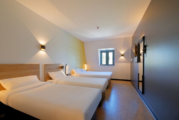 A hotel room with two beds, a window, and wall-mounted lights. - B&B HOTEL Le Touquet (Cucq)