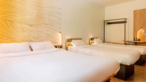 Habitación de hotel con dos camas, una lámpara de pared y un panel de madera.