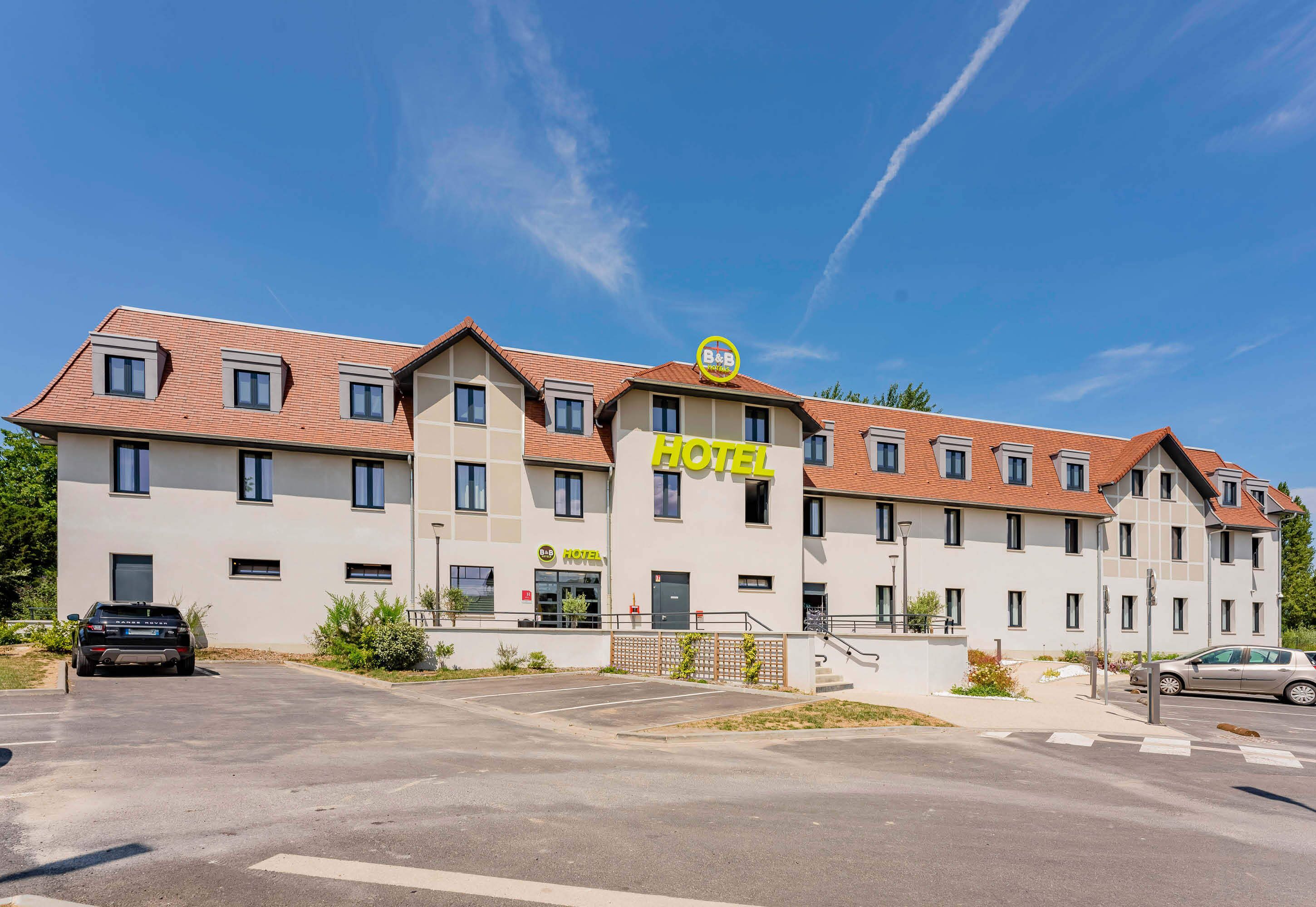 Een hotel met een modern design, meerdere verdiepingen en een opvallend 'HOTEL' bord.