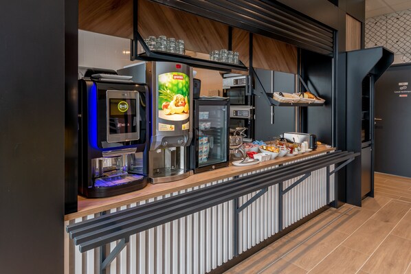 A modern kitchen area with a coffee machine, a refrigerator, and a microwave. There are also shelves with glasses and a counter with food items. - B&B HOTEL Brest Centre Port De Commerce (Brest)