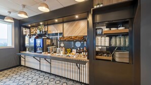 Una cocina moderna con barra, máquinas de café y diversos utensilios de cocina.