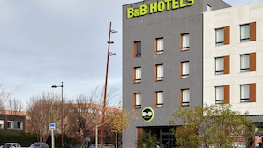 A B&B hotel with a modern brick facade, multiple windows, and a sign indicating it is a bed and breakfast. - B&B HOTEL Bois D'Arcy Saint Quentin en Yvelines (Bois-d'Arcy)