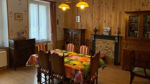 Un comedor con una mesa de madera, sillas y una chimenea.