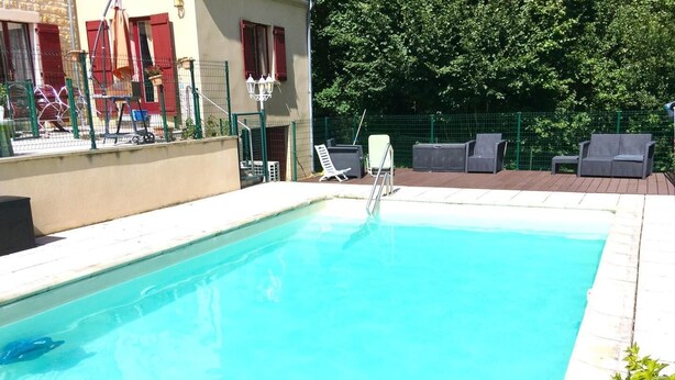 A rectangular swimming pool with a clear blue water surface, surrounded by a white tiled deck.