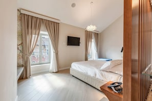 A bedroom with a bed, a TV mounted on the wall, and a window with curtains. - Oriana Homèl Udine (Udine)