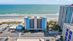 A multi-story parking garage with a view of the beach and ocean. - Oceanfront 3BR/2B  Springs Towers 704  Pool, Hot Tub, Fitness Room (North Myrtle Beach)