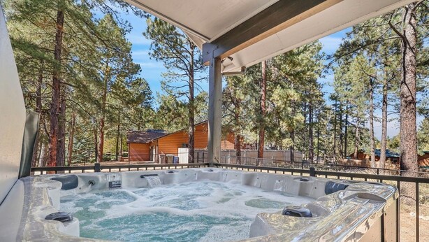 Un jacuzzi con una terraza de madera y vista a un área boscosa.