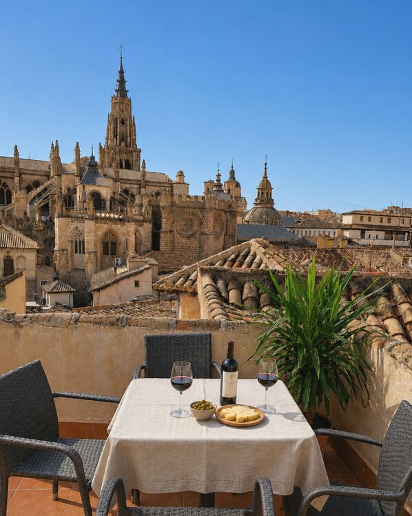 A terrace with a table set for two, overlooking a historic building with intricate architecture.