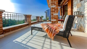 A balcony with a bed, a chair, and a table. - Sea view, garden with barbecue, pool with loungers, parking, air conditioning, wifi (Rojci)