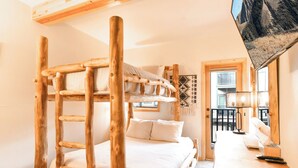 A bunk bed with a wooden ladder, a bedside table, and a mirror.
