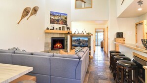 A cozy living room with a fireplace, a large TV, and a seating area.