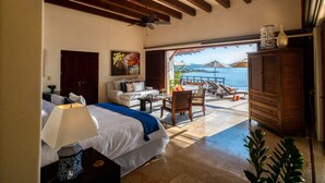 A bedroom with a bed, a desk, a chair, a nightstand, and a view of the sea. - Above Villa Paloma Blanca I Pool/Spa I Beach Club I Views I Spa (LA CRUZ DE HUANACAXTLE)