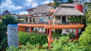 A resort with thatched-roof buildings, a pool, and lush greenery. - Above Villa Paloma Blanca I Pool/Spa I Beach Club I Views I Spa (LA CRUZ DE HUANACAXTLE)