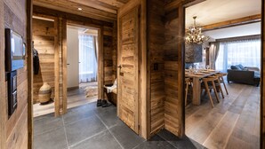 Un intérieur en bois comprenant un coin repas, un canapé et un lustre.