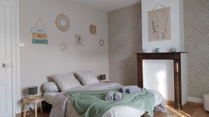 A bedroom with a bed, bedside tables, a fireplace, and wall decorations. - "Les 4 Fils Aymon" House overlooking the Meuse. (Bogny-sur-Meuse)