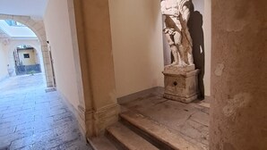 A stone staircase leading to an arched doorway with a statue. - Aristocratic Residence  (Verona)